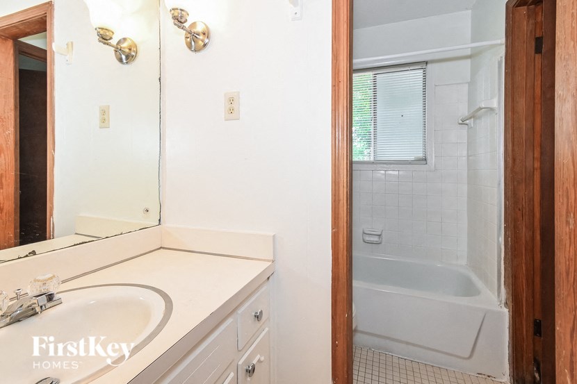A bathroom with a white sink and a white bathtub.