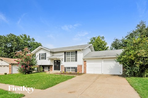 A house with a driveway and a garage is for sale.