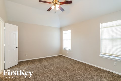 a bedroom with carpet and a ceiling fan