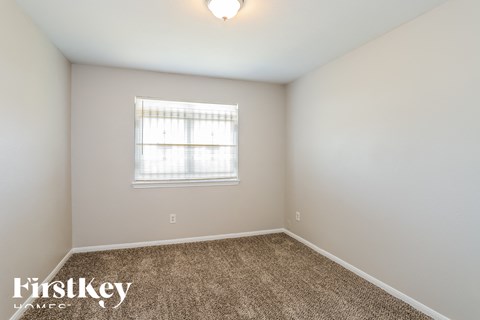 a spacious room with carpet and a window