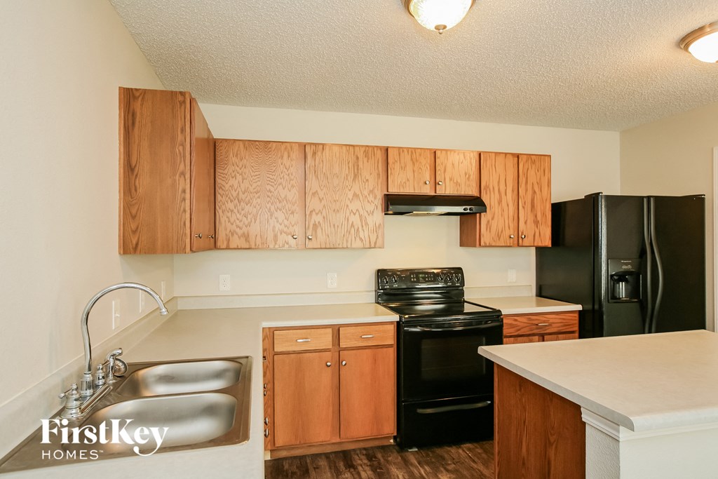 A kitchen with wooden cabinets and black appliances.