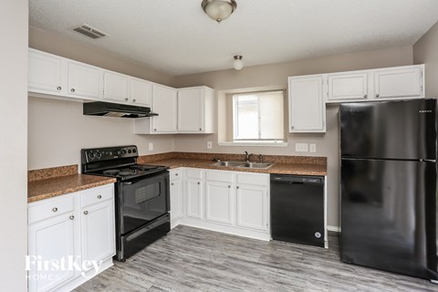 a kitchen with black appliances and white cabinets