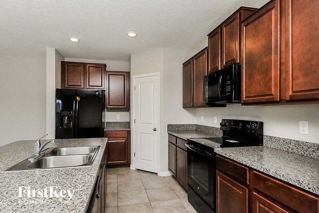 a kitchen with granite counter tops and black appliances