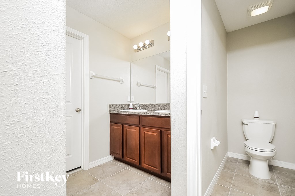 a bathroom with a toilet and a sink and a mirror