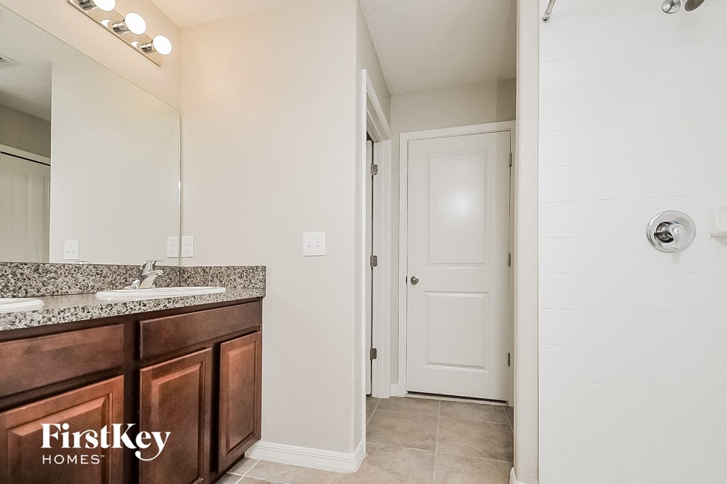 a bathroom with a sink and a mirror and a door