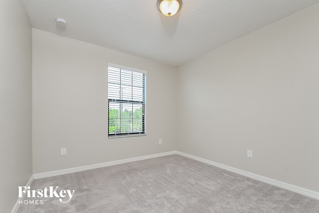 the living room of a new home with carpet and a window