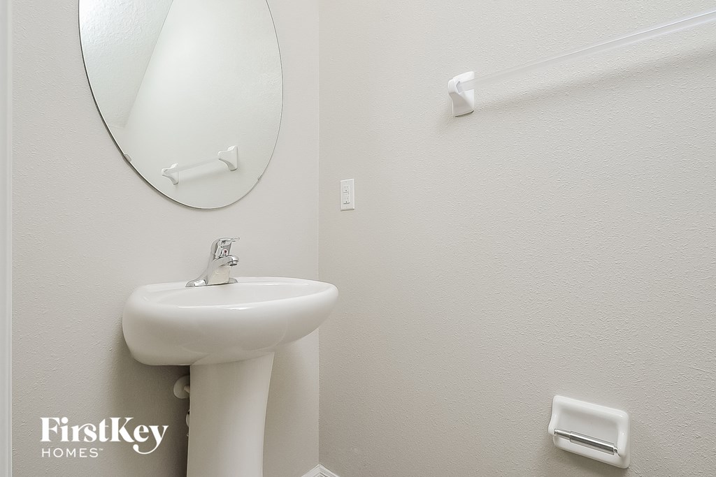 a white bathroom with a sink and a mirror