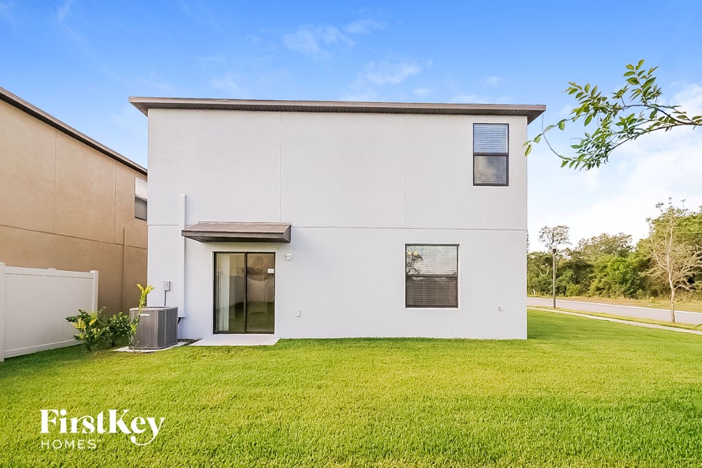 a white house with a green lawn and a sidewalk