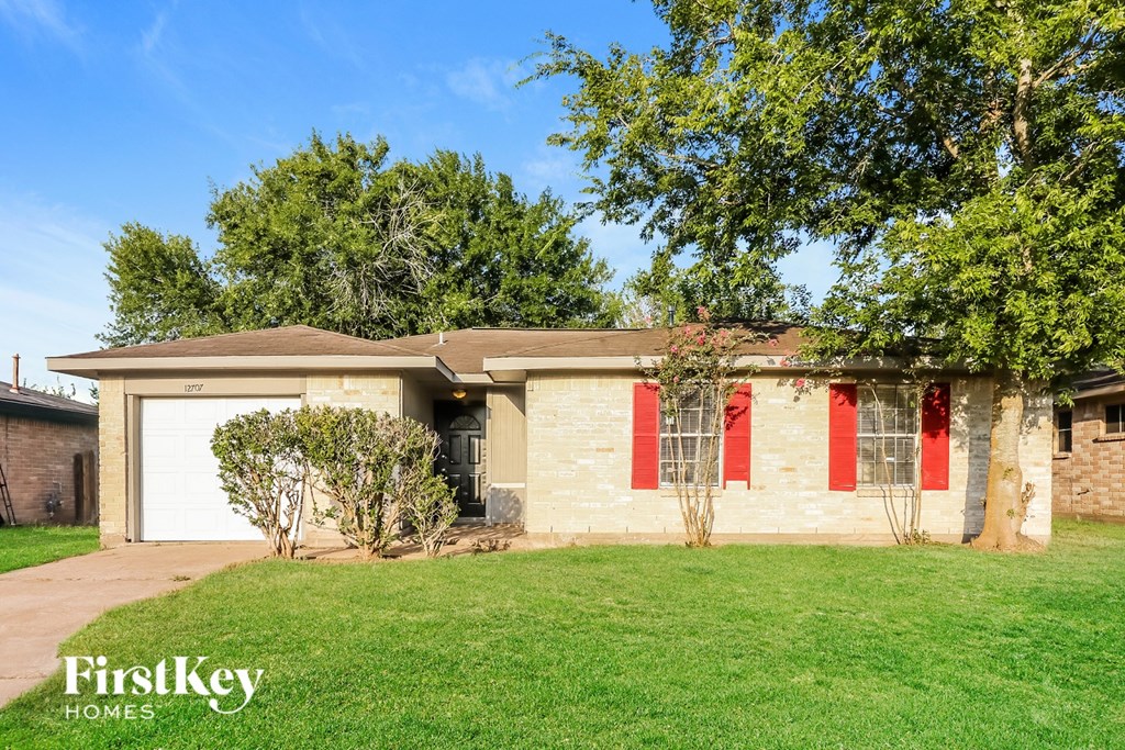 A house with a brown roof and red trim is for sale.