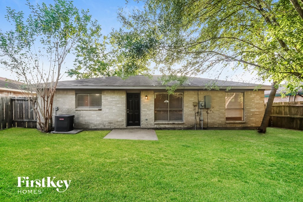 A house with a lawn and trees in front of it.