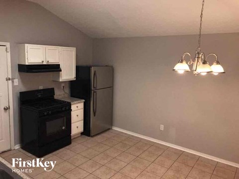 A kitchen with black appliances and white cabinets.