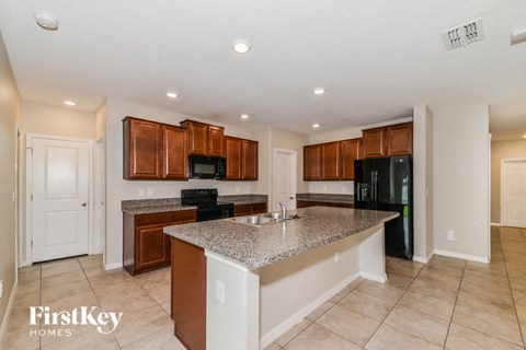 a kitchen with granite counter tops and black appliances