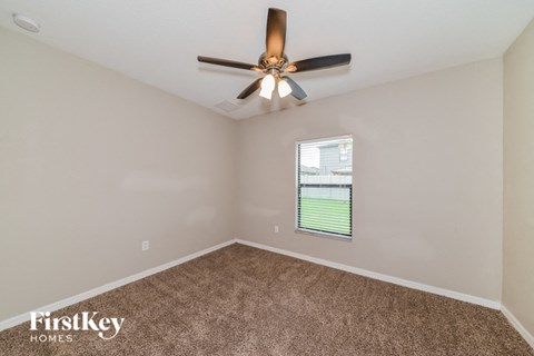 a bedroom with a ceiling fan and a window
