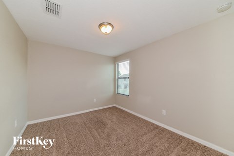 the spacious living room with carpeting and a window