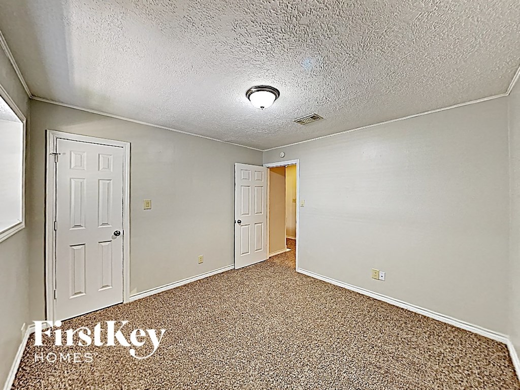 a bedroom with a white door and a carpeted floor
