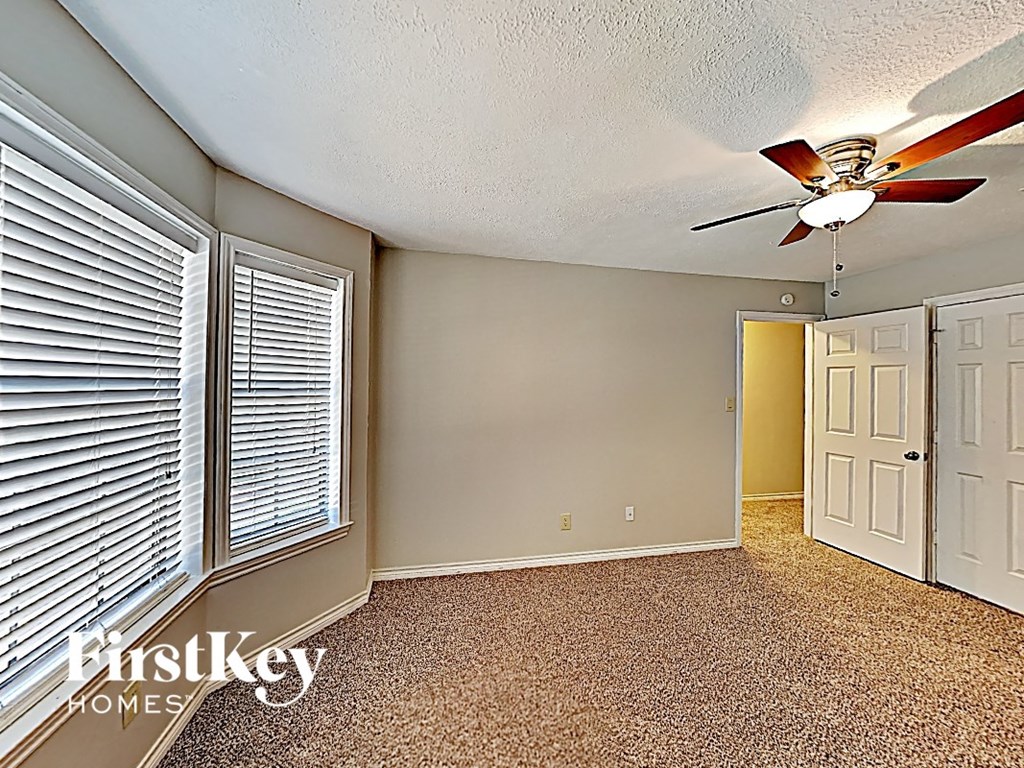 a bedroom with a ceiling fan and a closet