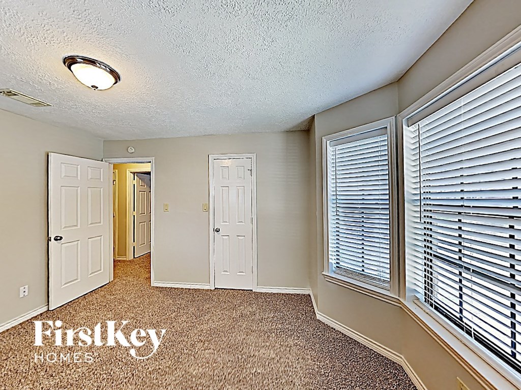 a bedroom with a large window and a door to a closet