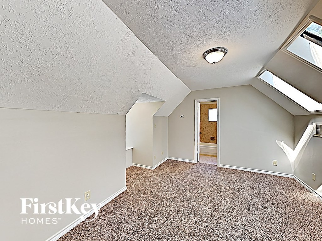 an empty attic with a door to a bathroom