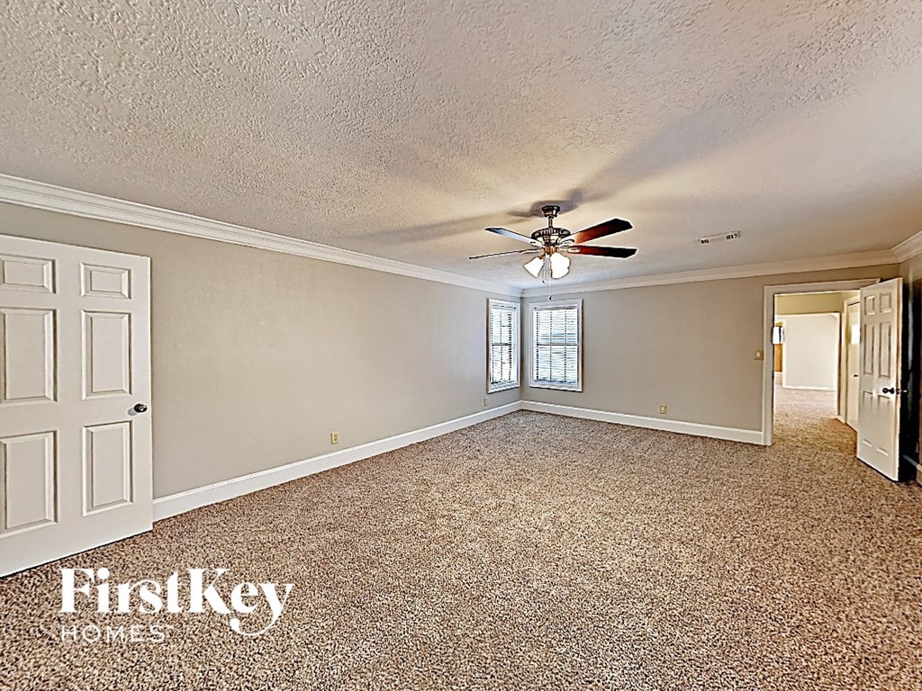 the living room of a house with a ceiling fan