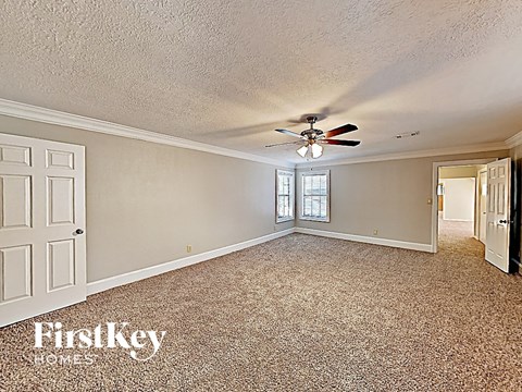the living room of a house with a ceiling fan