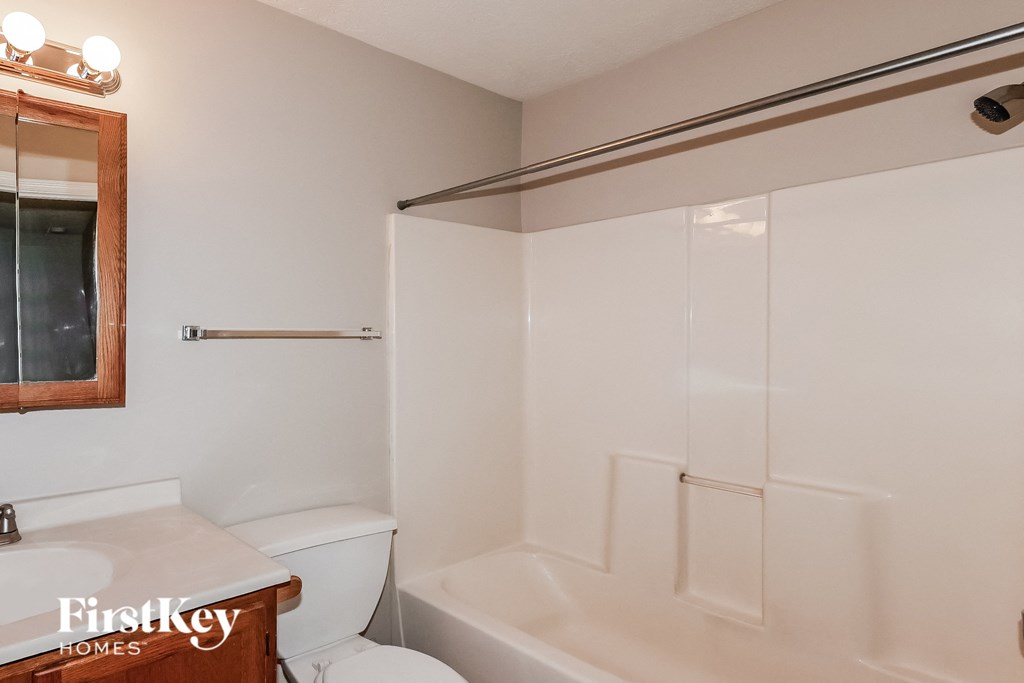 a bathroom with a toilet and a tub and a sink