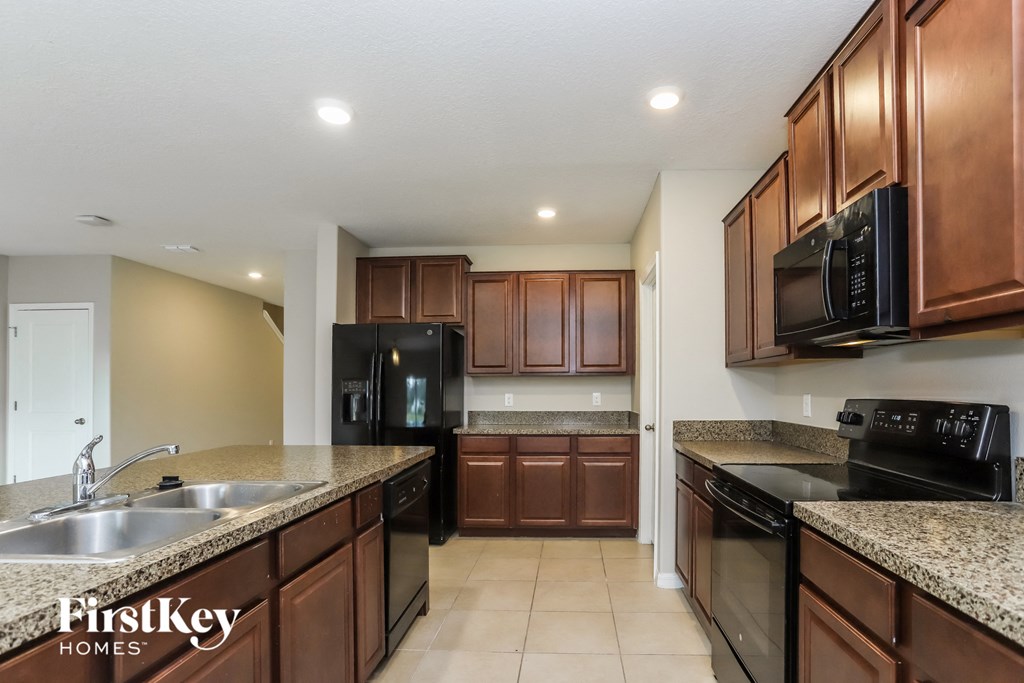 a kitchen with granite counter tops and black appliances