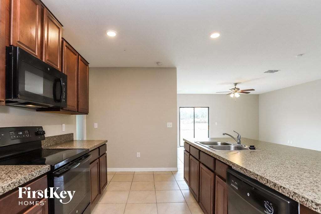 the kitchen has granite counter tops and stainless steel appliances