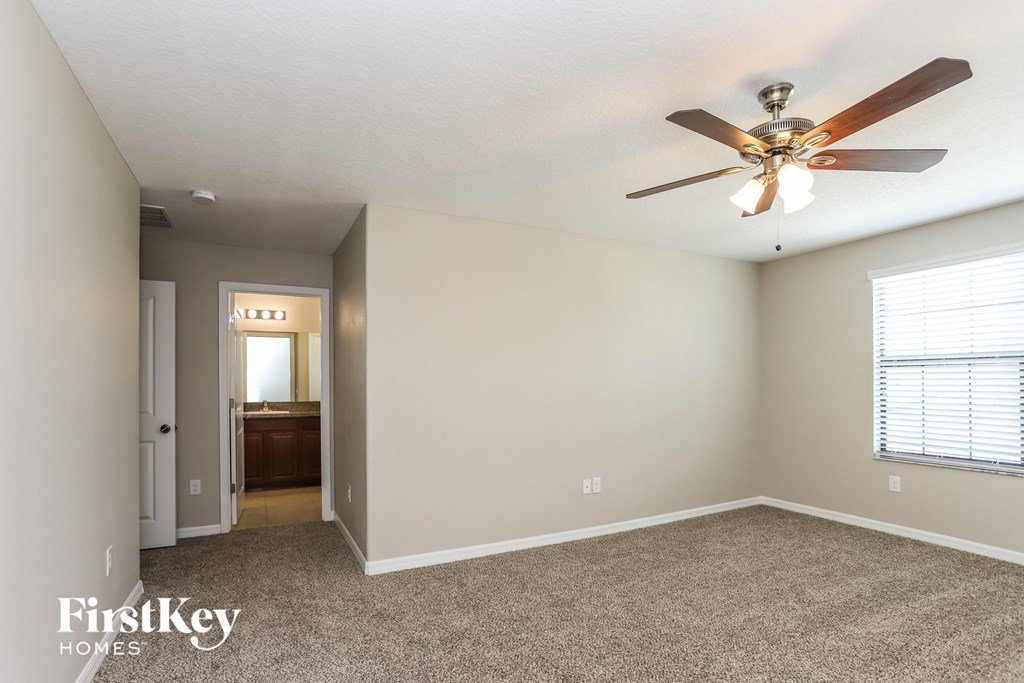 a living room with carpet and a ceiling fan