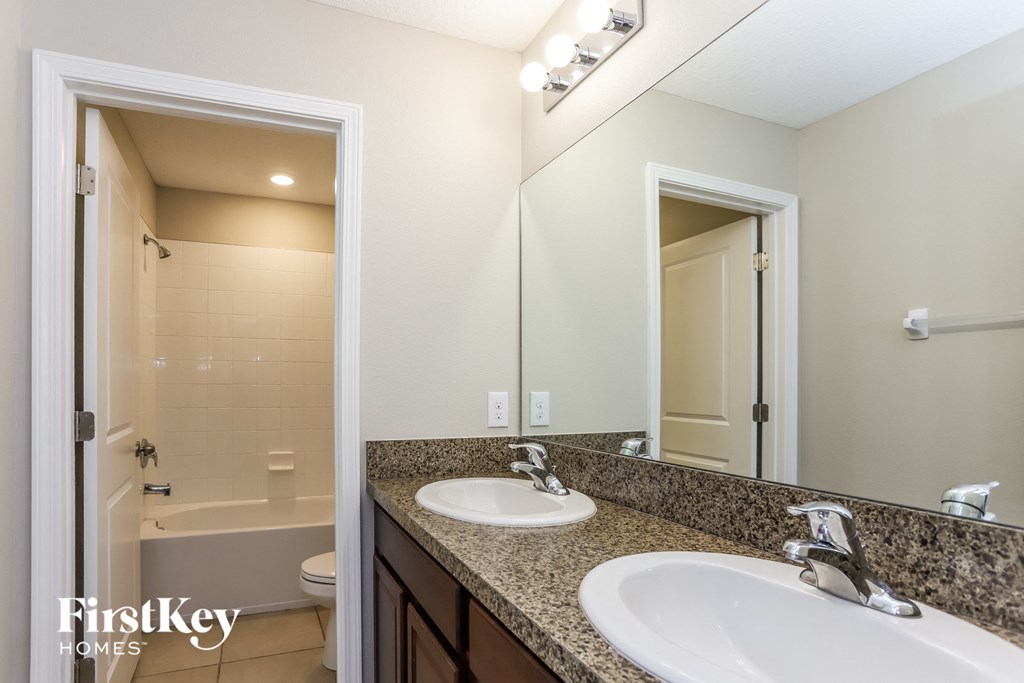 a bathroom with two sinks and a shower and a mirror