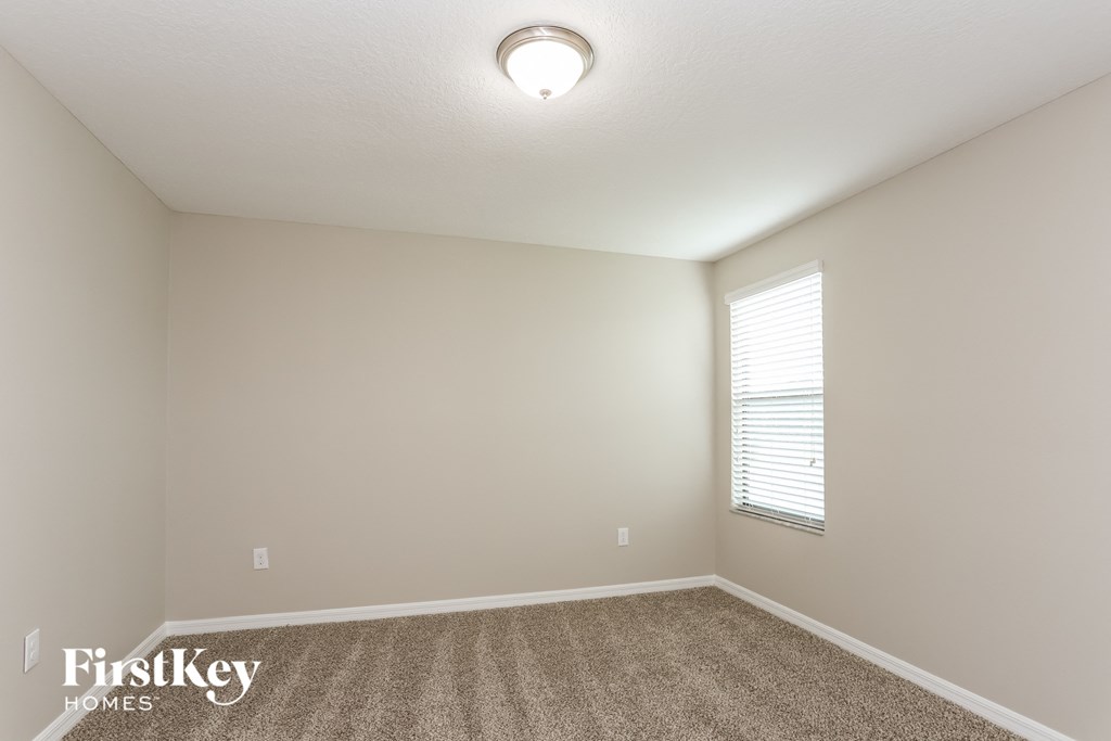 the spacious living room with carpet and a large window