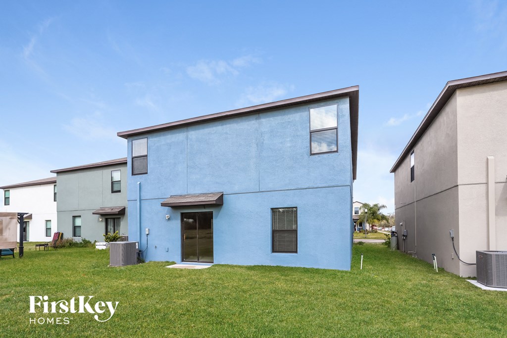 a blue house with a green lawn in front of other houses