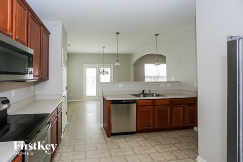 A kitchen with brown cabinets and a black counter top.