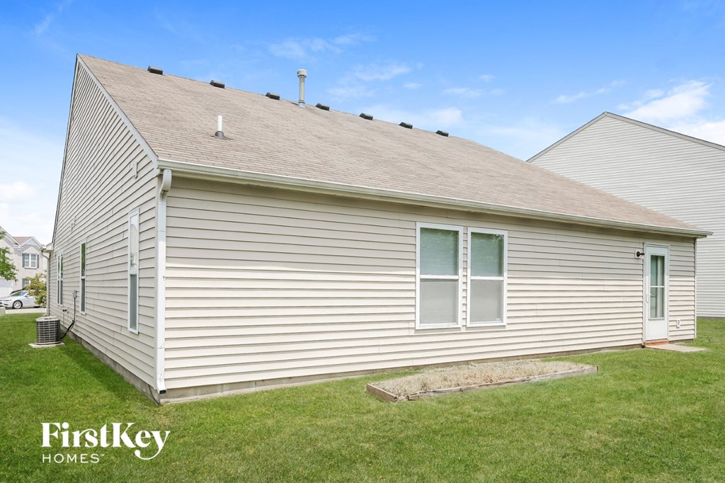 the front of a white house with a grassy yard