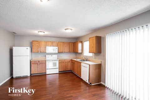 A kitchen with wooden cabinets and white appliances.