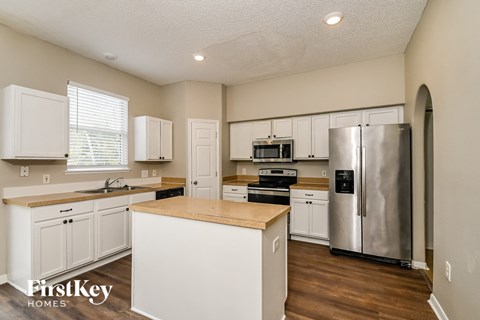 a kitchen with white cabinets and a stainless steel refrigerator