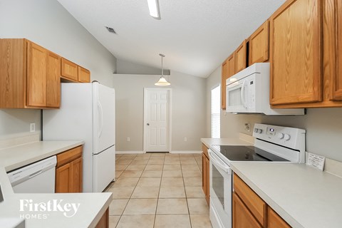 a kitchen with white appliances and wooden cabinets