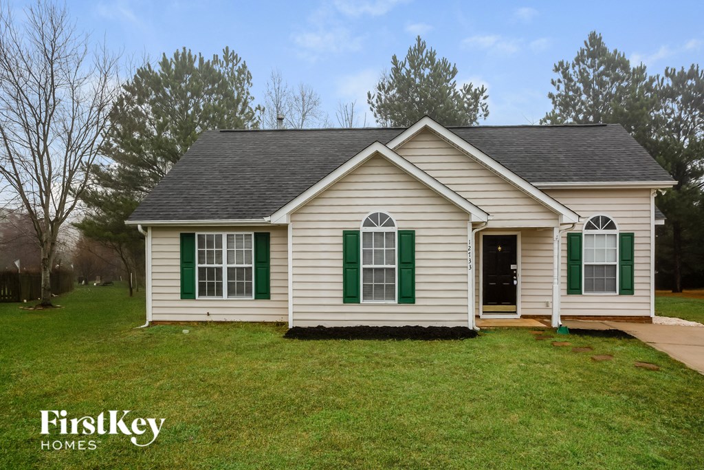 A small house with green shutters is for sale.