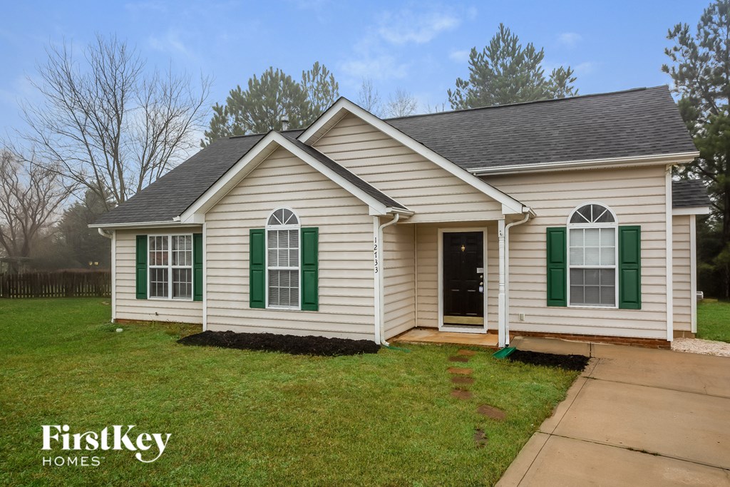 A small white house with green shutters is for sale.