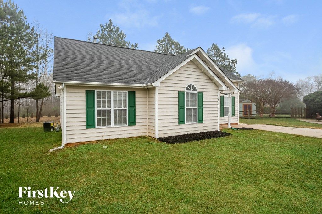 A small house with green shutters is for sale.