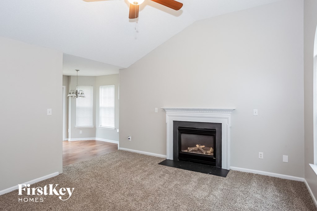 A living room with a fireplace and a fan.