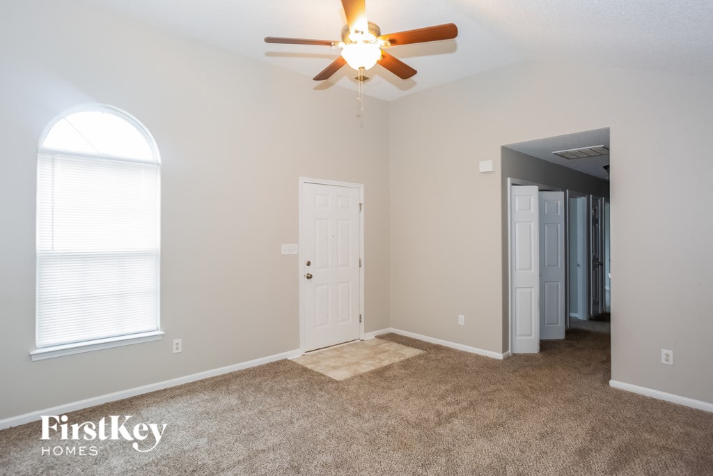 A room with a ceiling fan and a door.