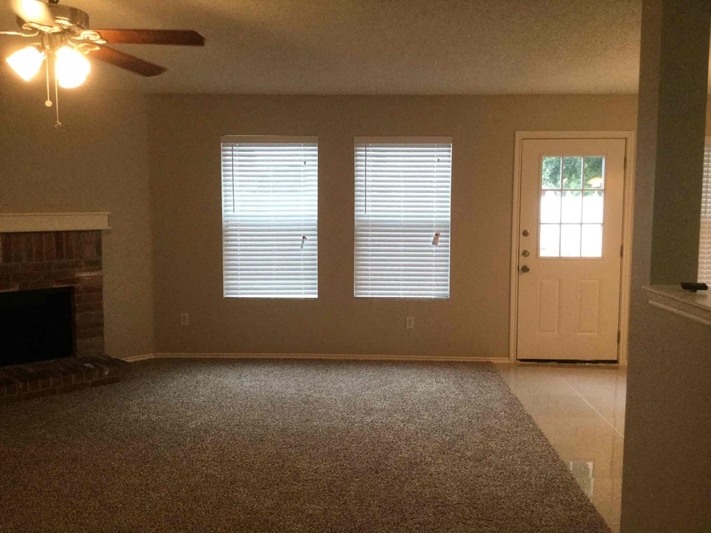 a empty living room with a fireplace and a door