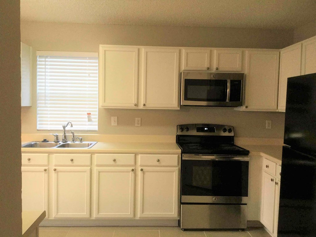 a kitchen with black appliances and white cabinets