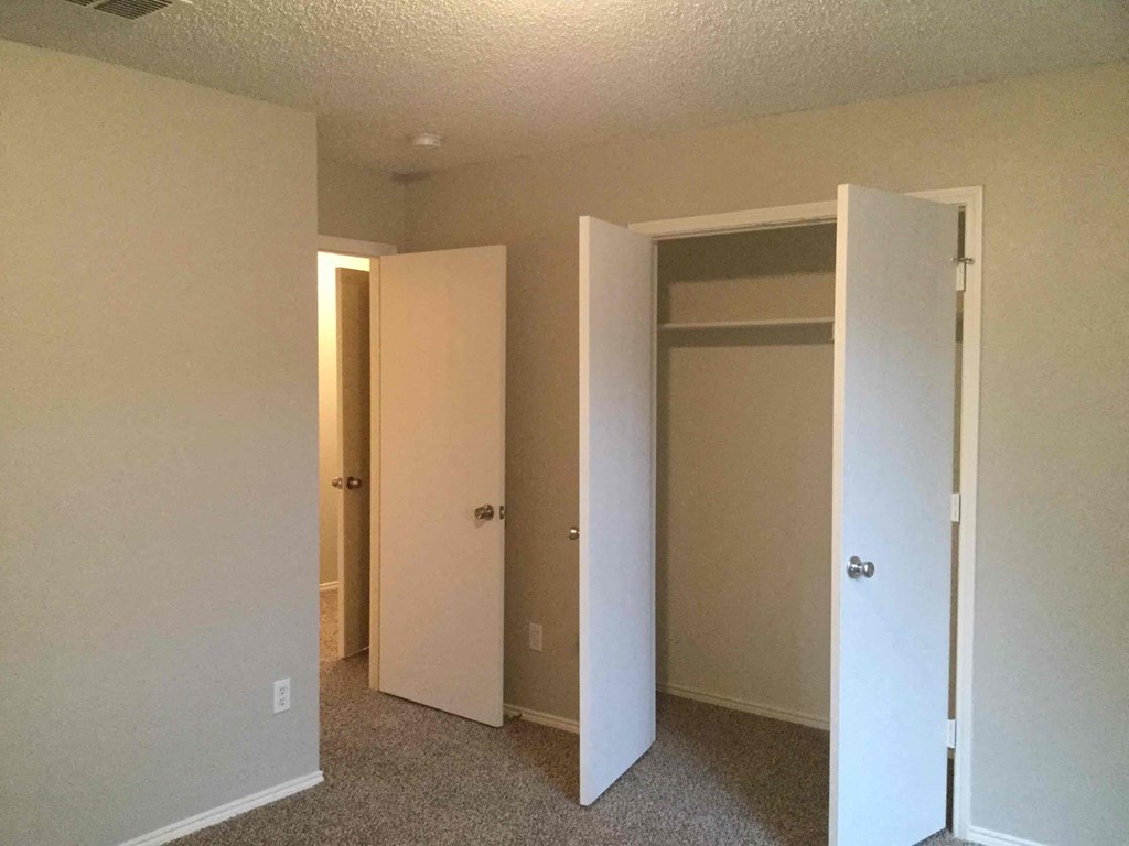 a room with three closets and a carpeted floor