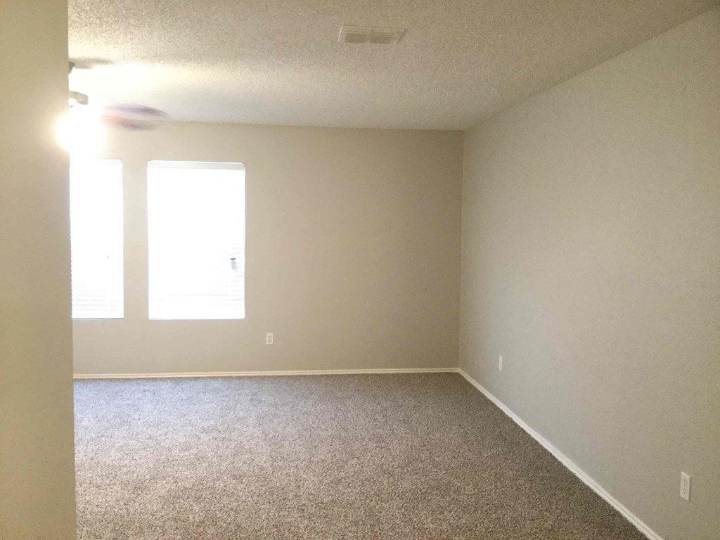 an empty room with white walls and a carpet