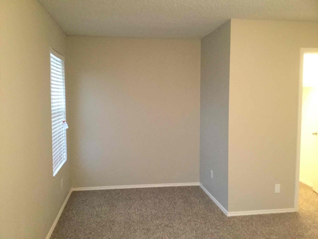 a empty room with beige walls and a window