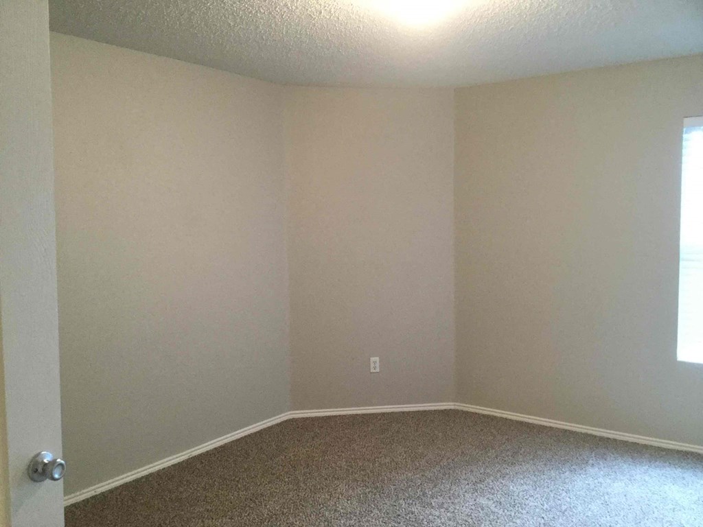 a empty room with white walls and a carpet