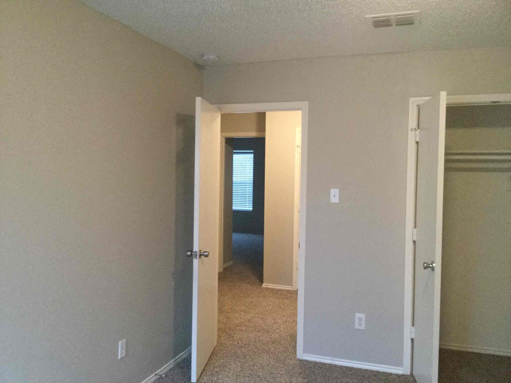 a room with a hallway with a closet and a door to a hallway