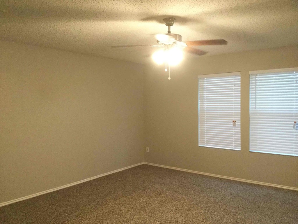 a bedroom with a ceiling fan and a window