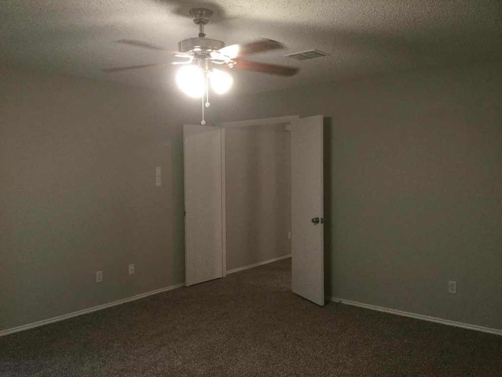 a bedroom with a ceiling fan and a closet